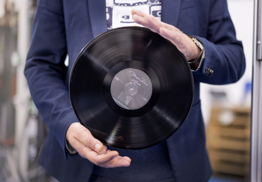 Jon Arne Alstad viser fram en vinylplate produsert i T-Time Vinyl Plant i Stavanger.